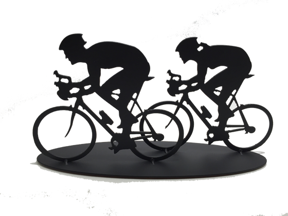 This metal sculpture shows the matte black silhouette a male and female cyclist riding together. The female cyclist is to the right and slightly behind the male. Both are hunched forward over their handle bars. The bikes are slightly simplified, and the wheels have no spokes. This piece sits on an oval base.