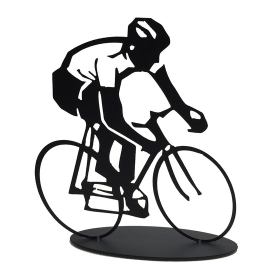 This metal sculpture shows the matte black silhouette of a cyclist riding a bike. The cyclist’s shirt has been cleverly made by punching out the metal, allowing the background to shine through. The piece is carved on a slightly slanted perspective, giving the impression that the cyclist is moving very quickly or beginning a turn. The piece sits on an oval base.