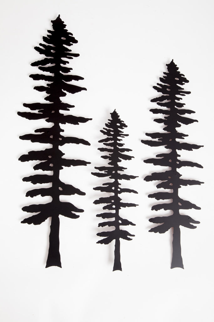 Three metal sculptures each show the matte black silhouette of a Sitka pine tree.  The designs of each tree are identical, but each sculpture is a different size, with the largest on the left and the smallest in the center. The Sitka tree is tall but slim. Its short, broad branches are about the same length along the whole tree, except at the top where they form a point. 