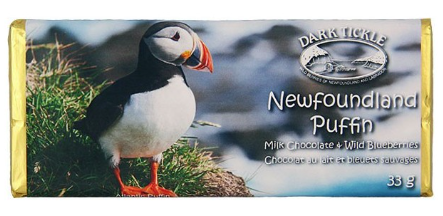 Small chocolate bar wrapped in gold foil. In a sleeve with photo of a Newfoundland Humpback Puffin on a patch of grass. 