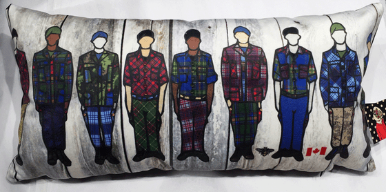 This large pillow features eight soldiers standing at attention. Each soldier is wearing long pants and a jacket with a unique colourful tartan print.  At the bottom right of the pillow is the artists mark—a small picture of a bee.