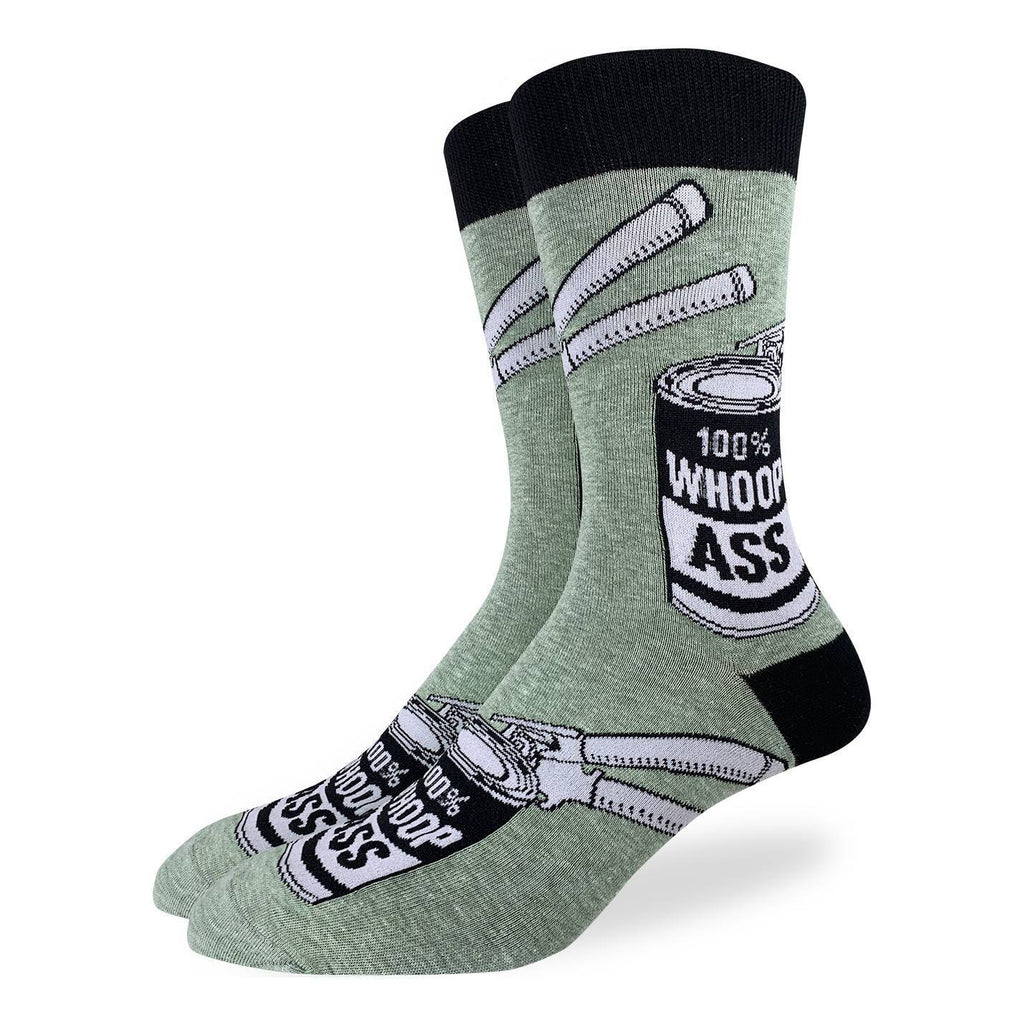 These fun socks feature a can with a label that says “ 100% WHOOP ASS”, and can opener on the can. The images are on a speckled olive-green background with a black heel and rim. Spandex added to the 85% cotton blend gives the socks the perfect amount of stretch to hug your feet.