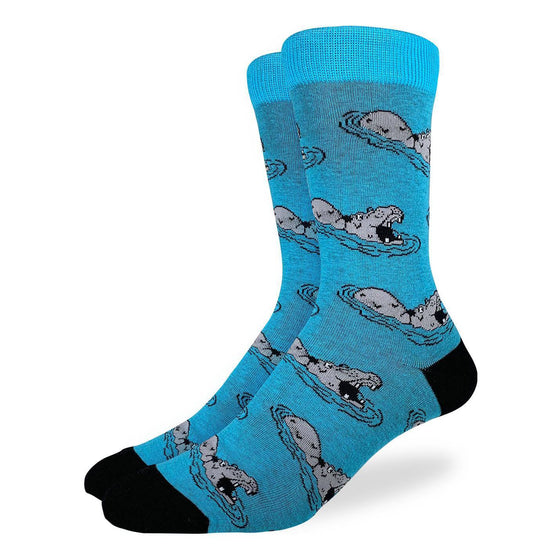 These fun socks feature grey hippopotamuses swimming in water with open mouths. The background of the sock is a water blue, and ripples come out from around the hippos. The heel and toe of the sock are black, and the rim is a light blue. Spandex added to the 85% cotton blend gives the socks the perfect amount of stretch to hug your feet.