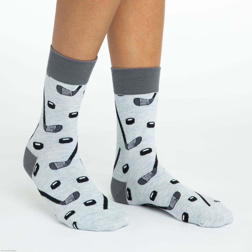 These fun socks feature black and white hockey sticks and pucks on a light grey background with a darker grey heel and rim. Spandex added to the 85% cotton blend gives the socks the perfect amount of stretch to hug your feet.