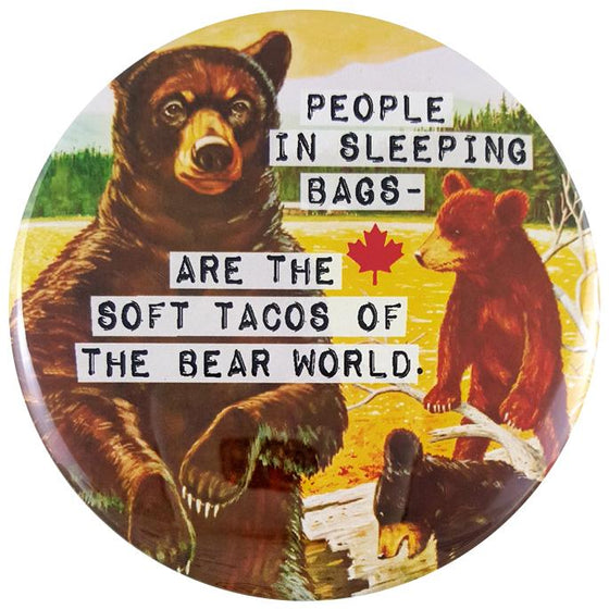 This round magnet shows a vintage picture of a mother bear and her two cubs. The mother bear is standing on her hind legs in front of a golden lake. Her cubs are playing on a log to her right. Across the picture the words “people in sleeping bags are the soft tacos of the bear world” are printed in black text against a white stripe. The text resembles a classic typewriter font.