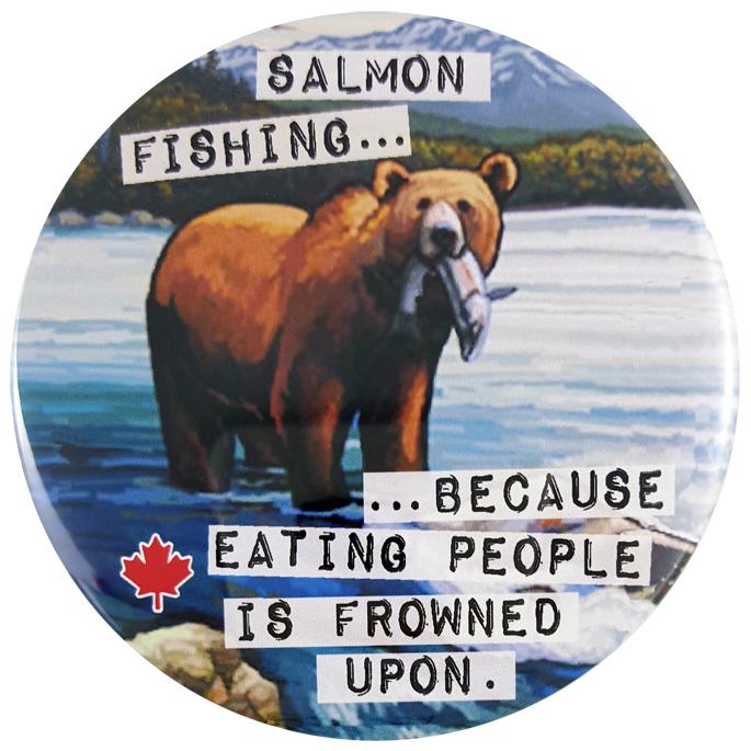 This round magnet shows a vintage picture of a grizzly bear at the top of a water fall. A salmon hangs from its mouth. Across the picture the words “salmon fishing…because eating people is frowned upon” are printed in black text against a white stripe. The text resembles a classic typewriter font.