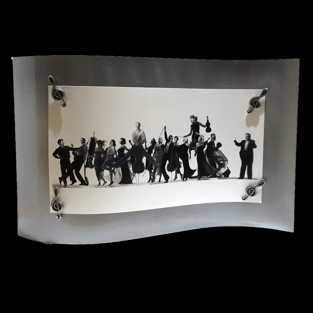 This frame consists of a single rectangular sheet of brushed steel, bent in a wave pattern so the single sheet stands on its own. A group photo of members of an orchestra is held on by four magnets in the shape of treble clefs.  