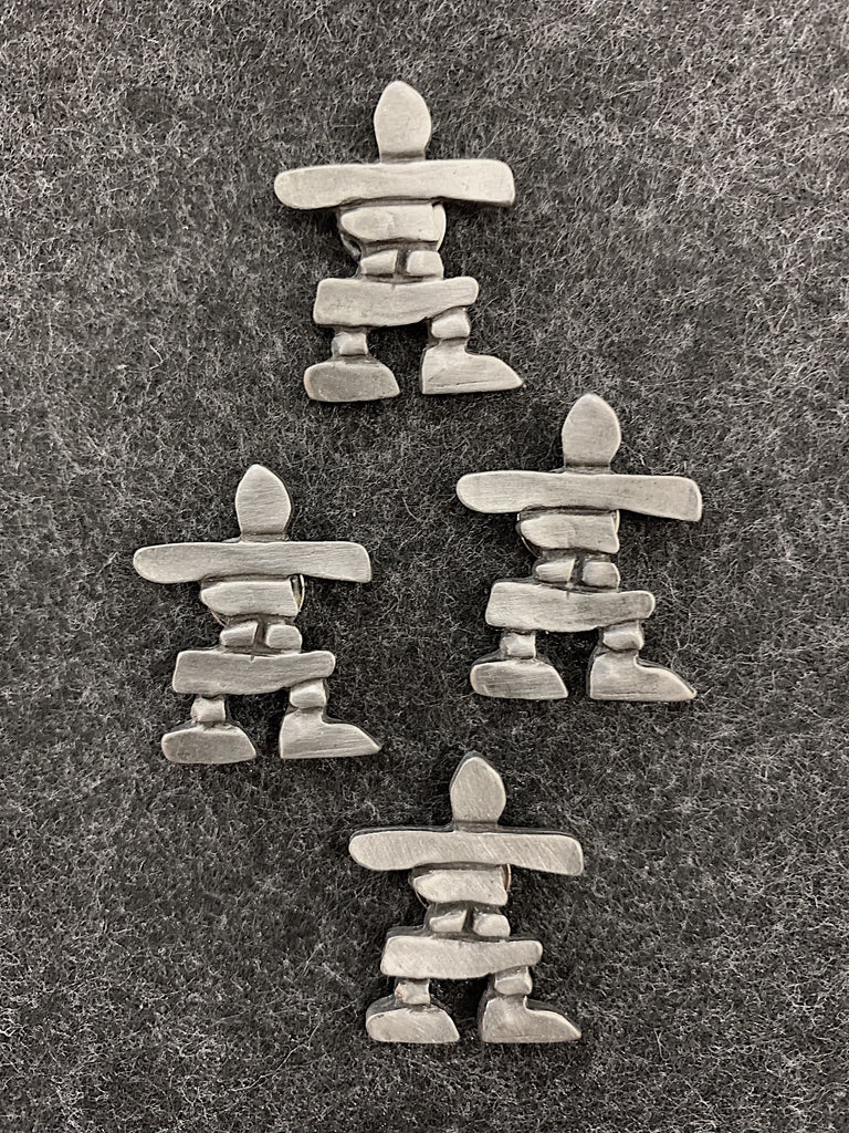 Four pewter magnets in the shape of inukshuks. 