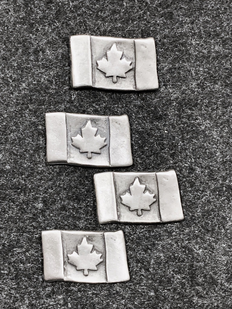 Four pewter magnets in the shape of Canadian flags. 