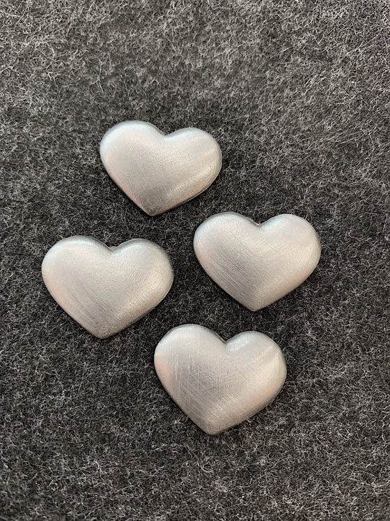 Four pewter magnets in the shape of plain hearts. 