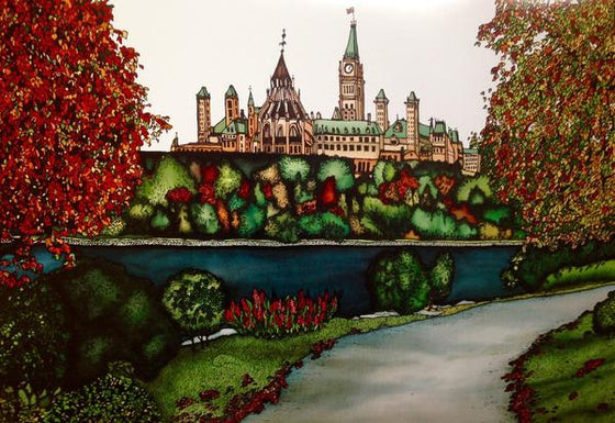 This rectangular magnet shows the Parliament building from across the Ottawa River. The river is dark blue and lined with trees, some of which are beginning to show their autumn colours. Curving up from the bottom to the right of the picture is a paved footpath. The picture is richly coloured.