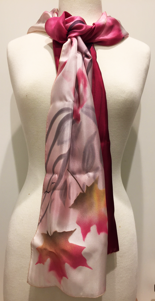 Pictured here is a deep pink/light pink/ivory hand-painted silk scarf featuring several Canadian maple leaves of various sizes.