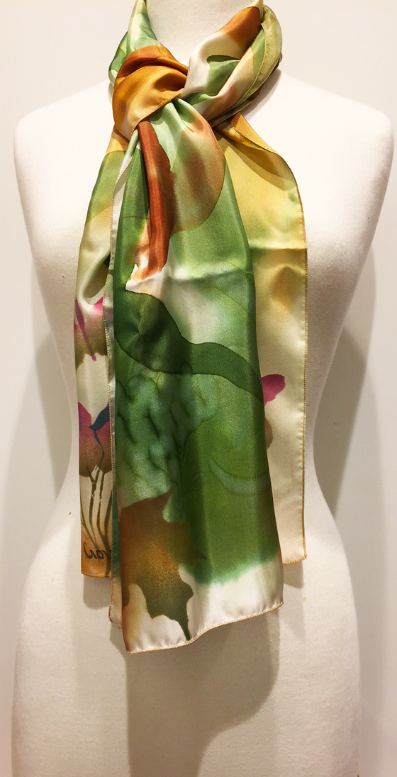 Pictured here is a green/gold/rust hand-painted silk scarf featuring several Canadian maple leaves of various sizes.