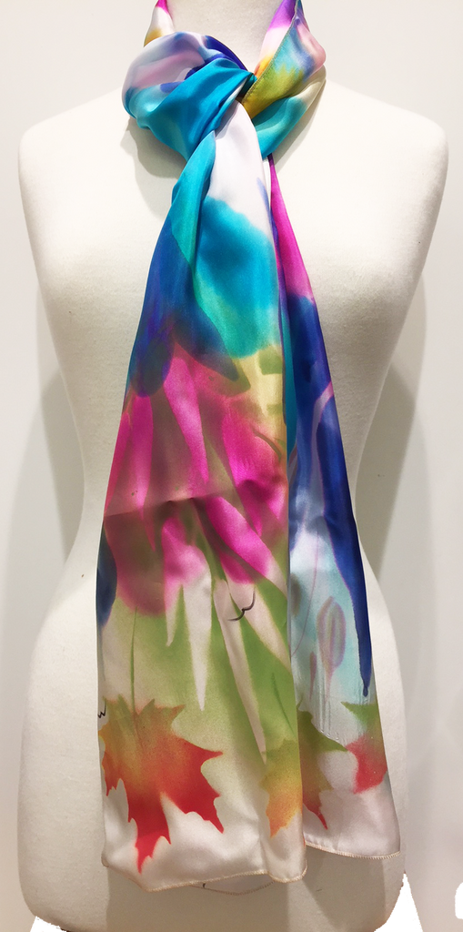 Pictured here is a royal blue/pink/teal/gold/green/ivory hand painted silk scarf featuring several Canadian maple leaves of various sizes.