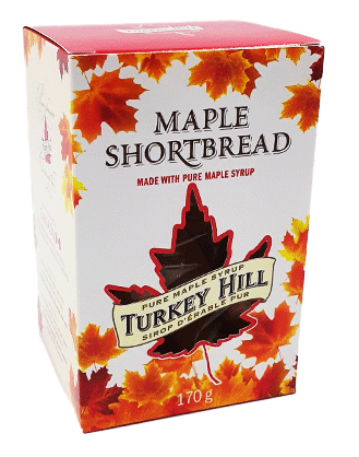 A leaf-shaped cut out shows the shortbread cookies inside. The red and white box is decorated with orange maple leaves.